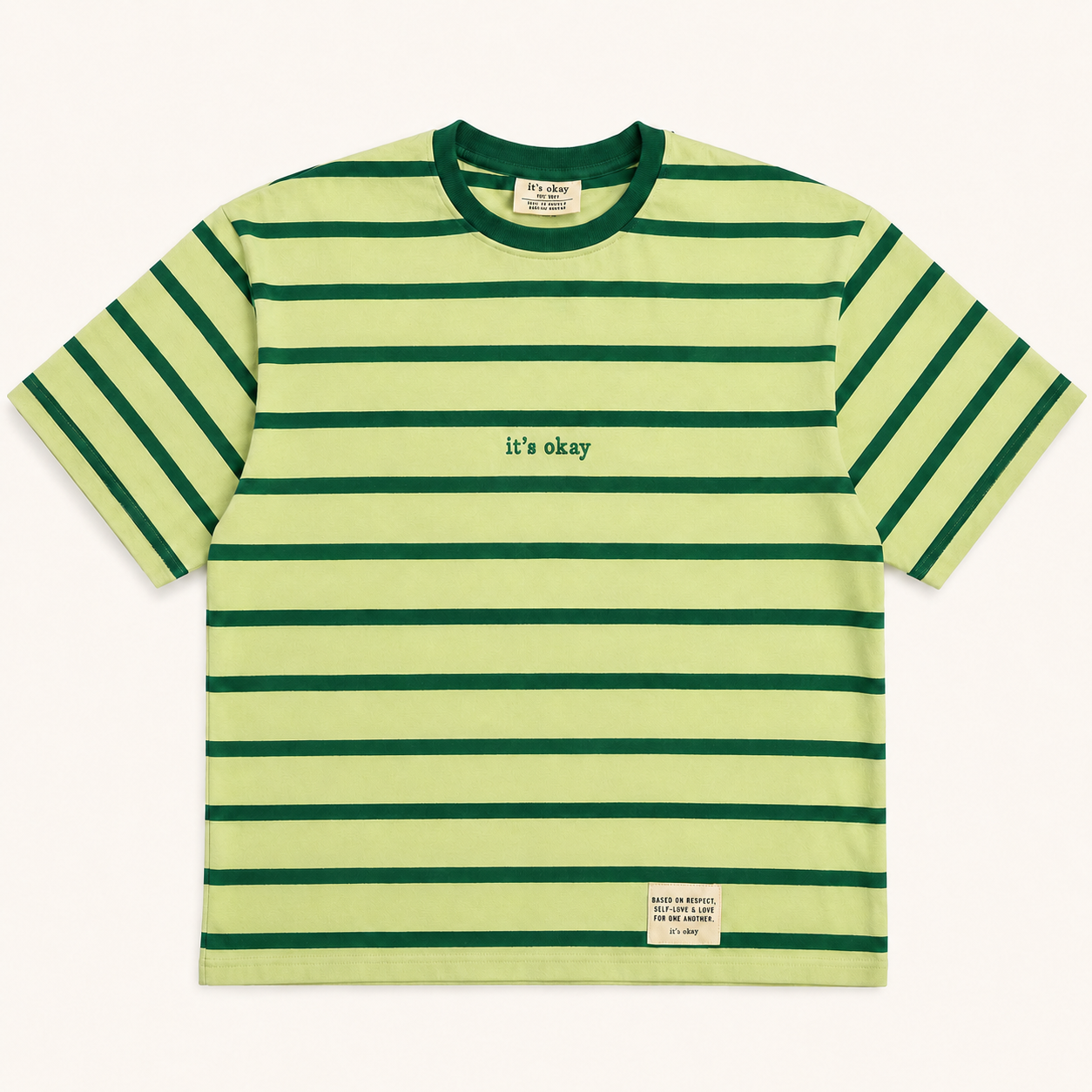 Green and yellow striped t-shirt with 'it's okay' text on a white background