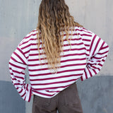 Person wearing a red and white striped shirt against a gray wall