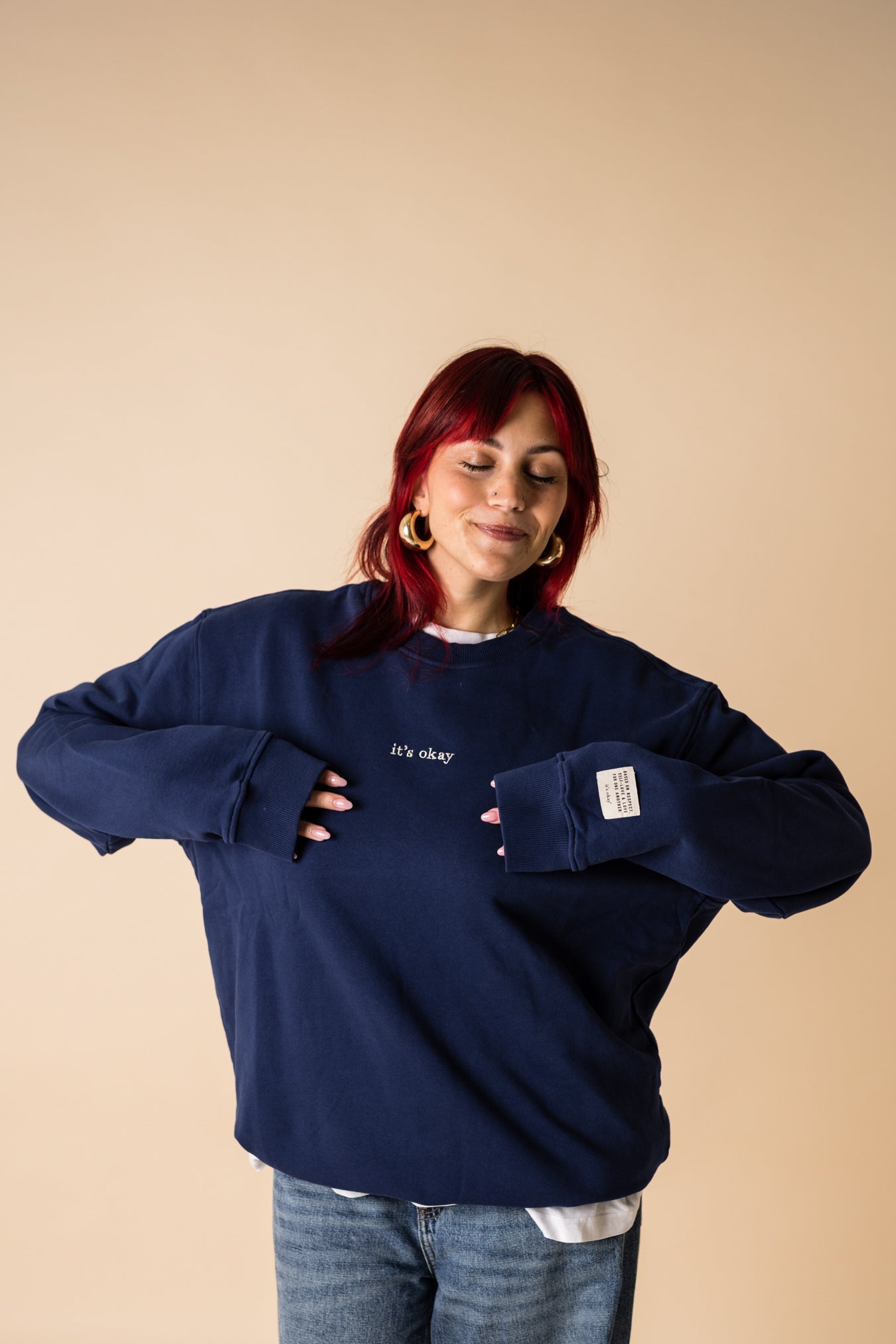 Woman wearing navy IT’S OKAY organic cotton crewneck, showing relaxed oversized fit.