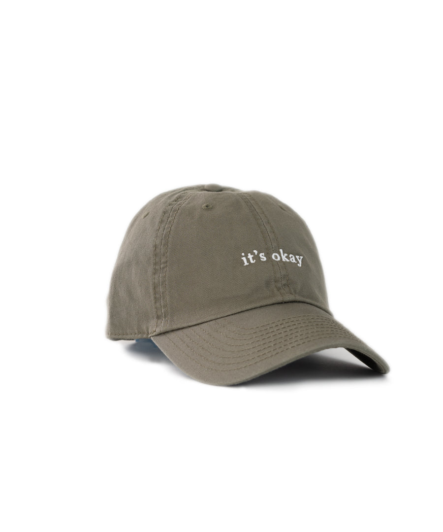 it's okay organic cap green| made with organic cotton, embroidered. This is a studio photography of the cap.