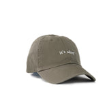it's okay organic cap green| made with organic cotton, embroidered. This is a studio photography of the cap.