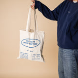 organic tote bag cultivate what matters, screenprinting, white and blue. Girl witrh crew blue pick up the tote bag.