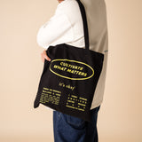 organic tote bag cultivate what matters, screenprinting, black and yellow. gut with cultivate crew wearing cultivate tote bag