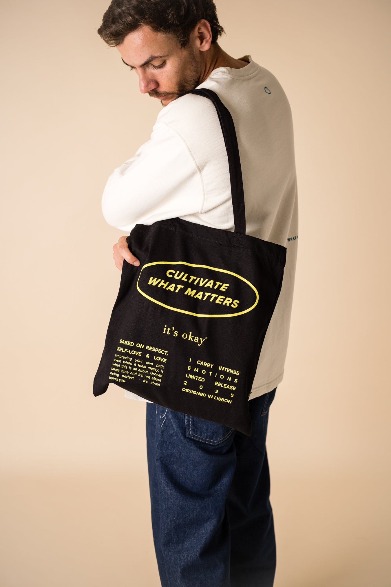 organic tote bag cultivate what matters, screenprinting, black and yellow. gut with cultivate crew wearing cultivate tote bag