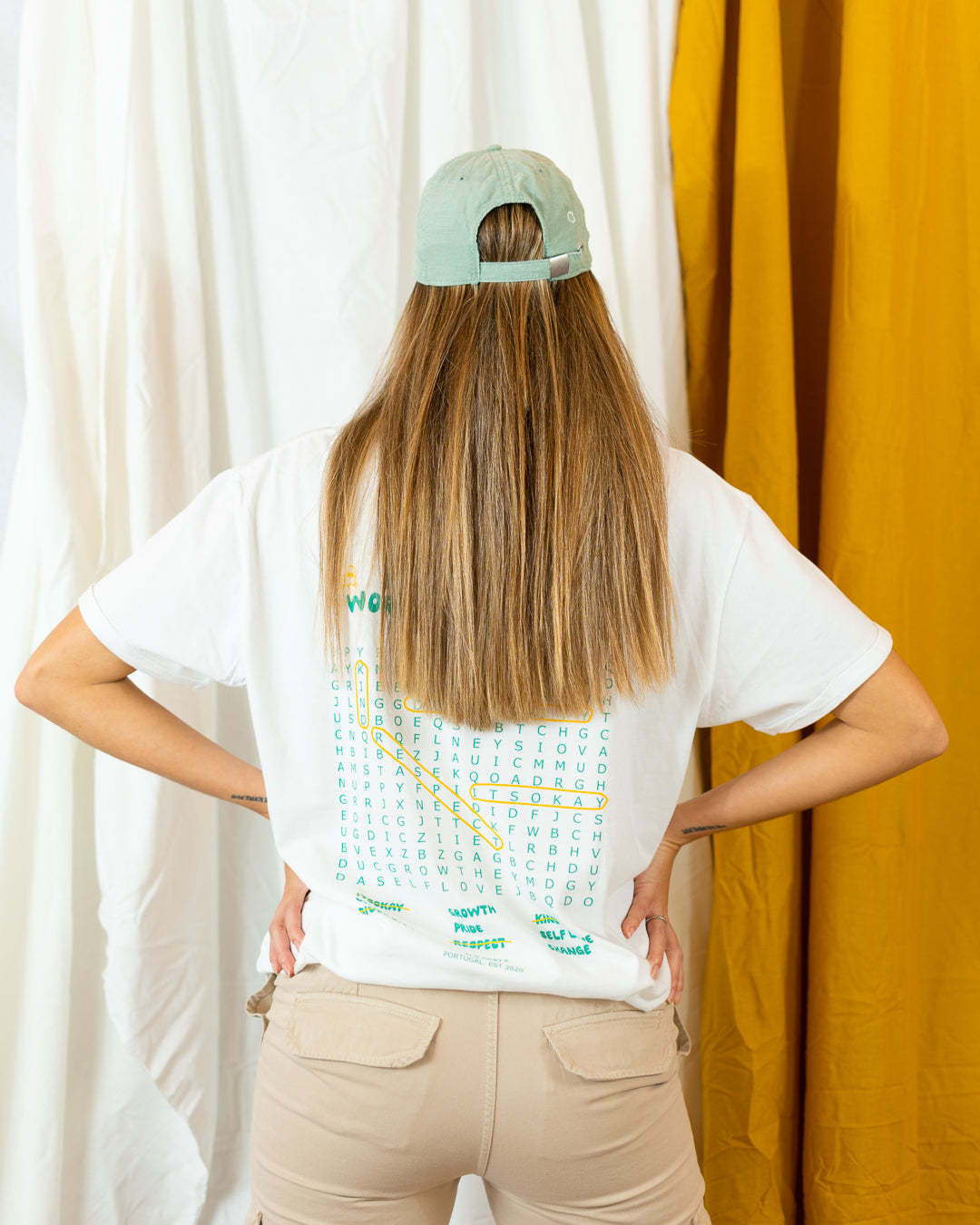 Wave cap | cotton needlecord corduroy in sage. Embroidered in Portugal. One size fits most | Wear it with pride. It's okay to be exactly who you are. Pt: Boné algodão de pala em bombazine de cor salvia, tamanha ajustável.  Image: long hair woman standing up with words search organic t-shirt and wave cap form it's okay. 